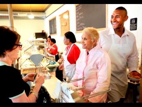 A customer picks up some to go food from Sweetie Pie’s owner Robbie Montgomery (centre), and Montgomery’s son James Timothy Norman (right), at Sweetie Pie’s in St Louis in this April 19, 2011 file photograph. A murder-for-hire trial involving former 
