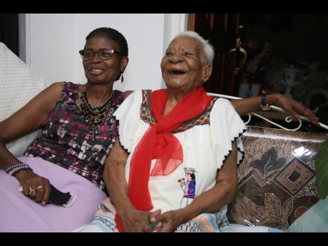 Julia Rose-Campbell, a centenarian of Hayes, Clarendon, shares a laugh with her 75-year-old daughter Marelyn Shaw as they reflect on happy memories. Rose-Campbell is 105. Nathaniel Stewart/Photographer