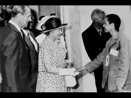 Broadcaster Fae Ellington greets Queen Elizabeth II during the royal’s 2002 visit to Jamaica. At left is Prince Philip, while to Ellington’s right is Ken Chaplin. Ellington said the photo and other memories will be in her memoir which she is putting to