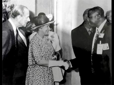 Gleaner photographer Rudolph Brown greets Queen Elizabeth II during her 2002 visit to Jamaica. Looking on is Prince Philip.
