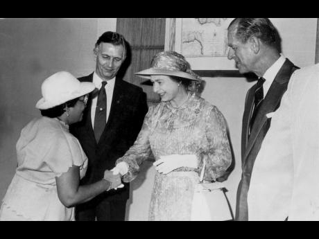 In this Gleaner photograph, State Minister Enid Bennett (left) shakes hands with Queen Elizabeth II at Gordon House on February 14, 1983, during the presentation of government members. Prime Minister Edward Seaga (second left) and Prince Philip look on.