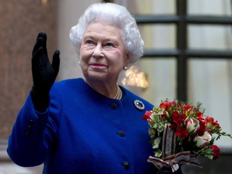 In this December 18, 2012 file photo, Britain's Queen Elizabeth II looks up and waves to members of staff of The Foreign and Commonwealth Office as she ends an official visit which is part of her Jubilee celebrations in London. 