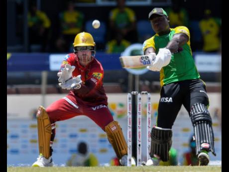 
Rovman Powell (right) of Jamaica Tallawahs hits a six as wicketkeeper Tim Seifert of Trinbago Knight Riders watch during the men’s 2022 Hero Caribbean Premier League T20 cricket match at Darren Sammy National Cricket Stadium in Gros Islet, St Lucia, yes