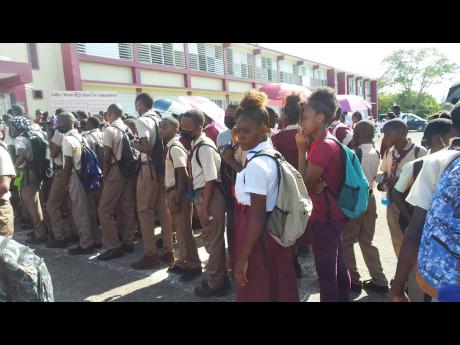Students of Godfrey Stewart High School in Savanna-la-mar, Westmoreland, congregate outside the institution’s front entrance after reportedly being denied entry on Monday because of dress code violations.
