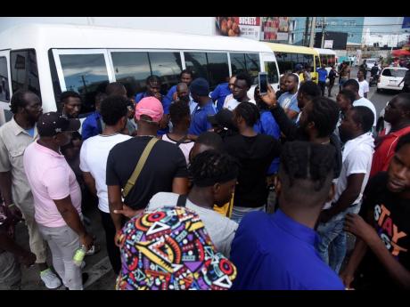 Bus operators who ply the Golden Spring to Half-Way Tree route in St Andrew in discussion on Monday as they withdrew their services, causing chaos for commuters.