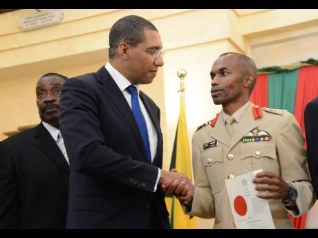 Prime Minister Andrew Holness shakes hands with then newly sworn in Major General Rocky Meade as chief of defence staff at King’s House on December 1, 2016. Meade, a retired lieutenant colonel, has been appointed Cabinet secretary and head of the public 
