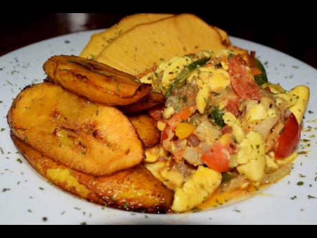 Ackee and salt fish is served with fried breadfruit and ripe plantains. 
