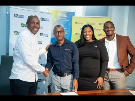 Professional Football Jamaica Limited (PFJL) Chairman, Chris Williams (left), shakes hands with JN Money Services’ General Manager, Horace Hines, while Assistant General Manager at JN Money, Sanya Wallace (second right) and newly appointed PFJL CEO, Owen