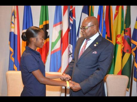Minister of Tourism Edmund Bartlett greets his junior tourism minister, Sanecia Taylor, of Manning’s School.