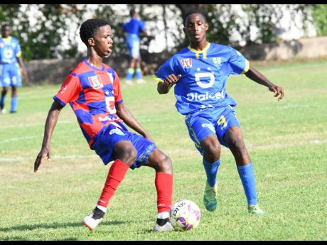 Roger Brown (right) of Papine High and Rhoniel Gordon of Camperdown High battle for the ball during the ISSA/Digicel Manning Cup match at Alpha Institute on South Camp Road yesterday. The game ended in a 1-1 draw. 