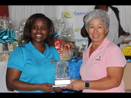 
President of the Kiwanis Club of New Kingston, Jhenell Allen (left), presents Susan White with her first-place trophy for winning the lady’s division of the Kiwanis Club of New Kingston Charity Golf Tournament, at Caymanas Golf and Country Club yesterda