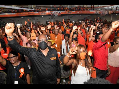 Dr Fenton Ferguson raises his fist  among People’s National Party supporters at the 84th annual conference inside the National Arena in Kingston on Sunday.
