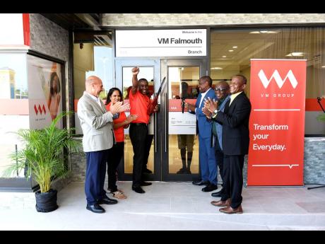 Sean Taylor (third left), branch manager, VM Building Society (VMBS) Falmouth branch, and Paul Elliott (fourth left), deputy CEO, VM Building Society operations, celebrate after cutting the ribbon to officially open the new location at Champion Plaza in th