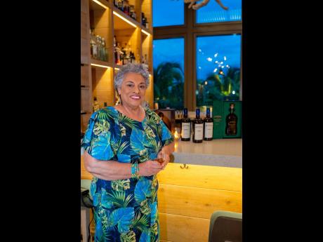 Dressed in tropical prints, Dr Joy Spence, master blender, Appleton Estate Jamaica Rum, smiles with her Decades blend in hand.