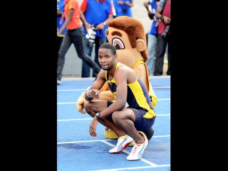 Delano Williams of Munro College poses with masot ‘Champsy’ after winning the Class One 200 metres final at the 2013 ISSA/GraceKennedy Boys and Girls’ Championships.