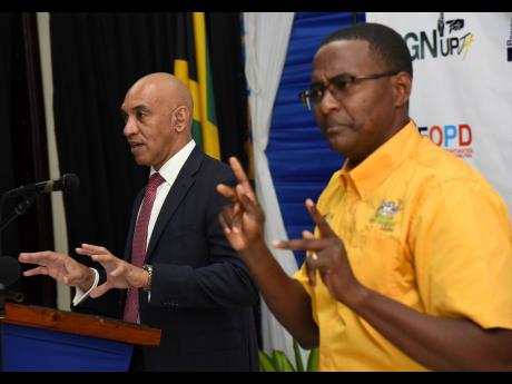 Denque Wedderburn (right) translates Police Commissioner Antony Anderson’s remarks to sign language during the Sign Up Jamaica graduation ceremony at the Police Officers Club in St Andrew on Thursday.