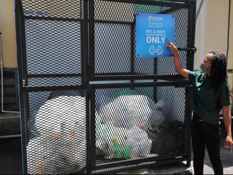 General Manager Tamii Brown points to a notice reminding workers to recycle their plastic bottles.

