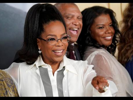 Oprah Winfrey, left, a producer of ‘Sidney’, gestures to a photographer alongside the film’s director Reginald Hudlin, centre, and Sidney Poitier’s daughter Sherri at the premiere of the documentary film.Oprah Winfrey, left, a producer of ‘Sidney
