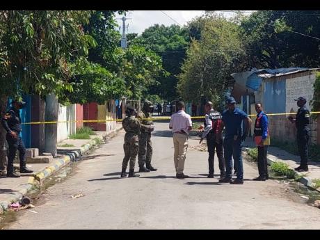 Members of the security forces at the scene on Crescent Road in St Andrew, where two men were shot dead and another injured on Friday morning.