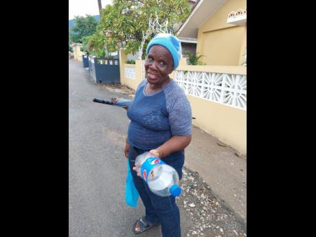 Elaine Nixon from Weise Road in St Andrew off to buy kerosene oil as she prepares for the impact of the weather system affecting the island.