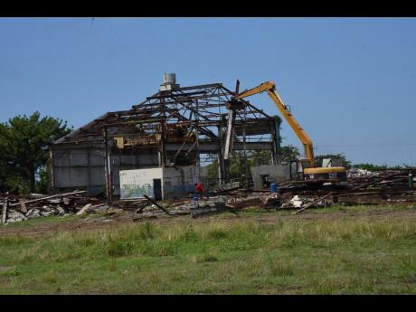 An equipment demolishing a section of the Goodyear tyre factory ruins in St Thomas on September 8. The Morant Bay Urban Centre is to be established on that property.