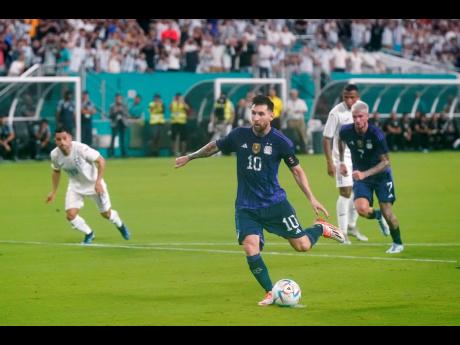 Above: Argentina forward Lionel Messi scores a penalty against Honduras during the first half of an international friendly football match in Miami Gardens, Florida last Friday. Argentina won 3-0. 