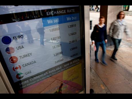 People walk past a currency exchange bureau in London, Monday, September 26, 2022.