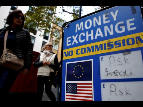 People walk past a currency exchange bureau in London, on Monday, September 26. 