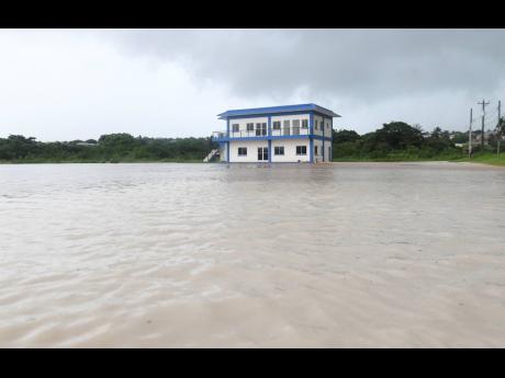 The newly built Green Acres Police Station on St John’s Road, Johnson Pen, is swamped by floodwaters on Monday. Built at a cost of $73 million, drainage works of at least $260 are yet to be undertaken to alleviate the flood risk.