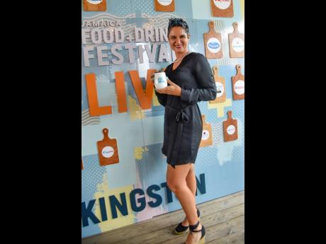 Director of The Life Store and ticket ambassador, Natalie Murray, beams with radiance, showing off her Jamaica Food and Drink Festival tumbler.