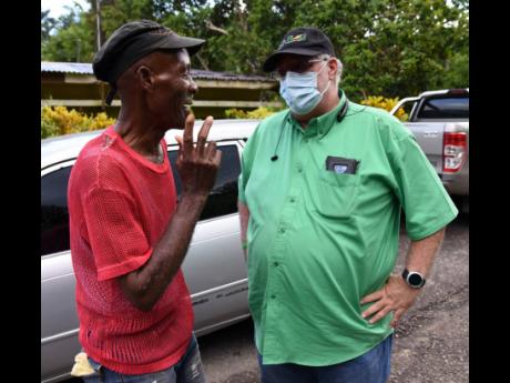 Phillip Henriques (right), then Jamaica Labour Party (JLP) caretaker candidate for Clarendon North Western, interacts with an unidentified constituent at a grave-digging in Effort district, Clarendon, on August 13, 2020. Henriques, who was elected member o