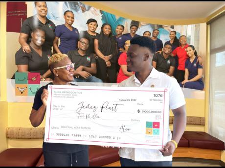 Orthodontist Dr Anna Law presents a $5-million cheque to UWI final-year dental student, James Peart, to cover his tuition and expenses for the 2022/2023 school year. Dr Law spotted Peart’s plight through a Gofundme request and tapped her company, Align O