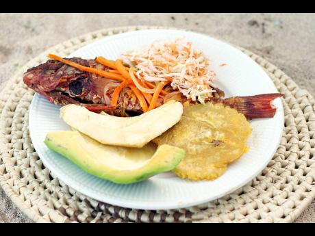 The escoveitch fried fish and fried pressed green plantain was the first thing to go off the buffet table set up by Oshea’s 876 Kitchen on the beachside in Norwich.