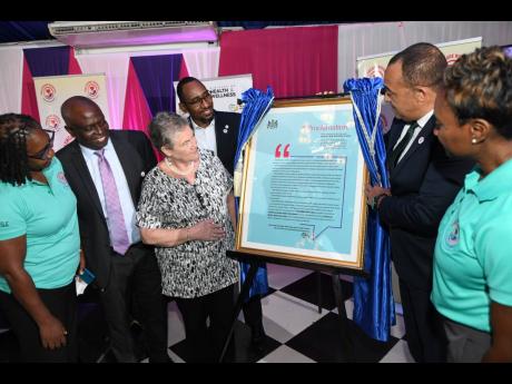 Dr Christopher Tufton (second right), minister of health and wellness, and Juliet Cuthbert-Flynn (right), minister of state, observe the unveiling of a proclamation at the official launch of Healthcare Workers Appreciation Month on Monday, July 4. Looking 