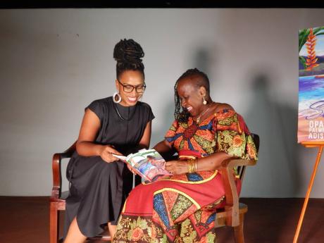 Dr Isis Semaj-Hall (left) and Opal Palmer Adisa, author of ‘The Storyteller’s Return: Story Poems’ peruse the new book.