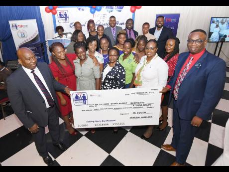  Wilton South (front left), general manager of TIP Friendly Society, and Dr Garth Anderson (front right), president, TIP Friendly Society, hold the cheque for $3,860,000 to be disbursed to 54 students as education grants. In the background are some of the 