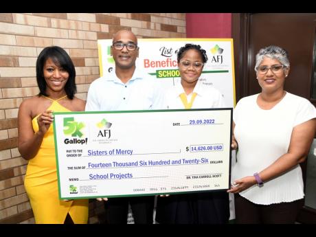 Dr Tina Carroll-Scott (left) presents more than US$14,000 to (from second left) Charles Arumaiselvam, development officer of Sisters of Mercy; Trivian Johnson, head girl of the Convent of Mercy Academy ‘Alpha’; and Principal Kali McMorris.