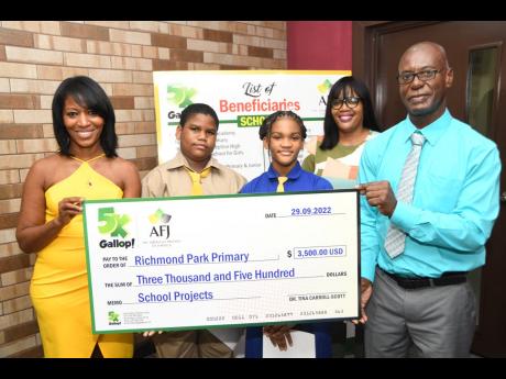 From left: Dr Tina Carroll-Scott (left) of 5K Gallop and on behalf of American Friends of Jamaica presents a symbolic cheque for US$3,500 to Richmond Primary School students Danir Brown and Ariel Mears; Melissa McGowan-Wright, guidance counsellor; and Prin
