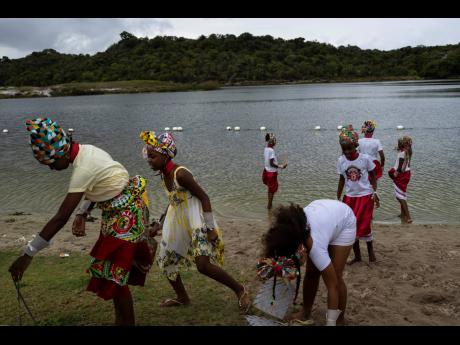 
Afro Brazilian community members take part in a protest alongside the Abaete Lagoon in Salvador, Brazil, Sunday, Sept. 18, 2022. Protesters called on authorities to take action against projects that would have environmental impact on the dunes, including 