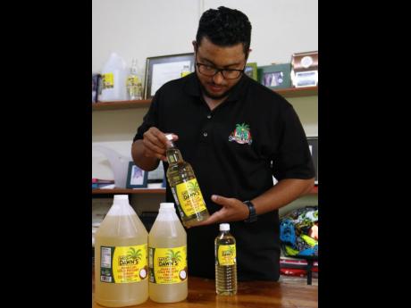 Zachary Black makes a point about the availability of Miss Dawn’s Jamaican cold compressed virgin coconut oil, which is marketed in four sizes, during a visit to Michael Black Farms Limited in Nutts River, St Thomas.