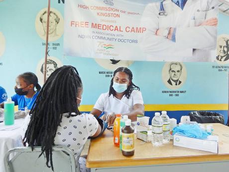  A St Ann resident receives medical attention at Sunday’s health camp staged by the Indian High Commission at the Ocho Rios Primary School.