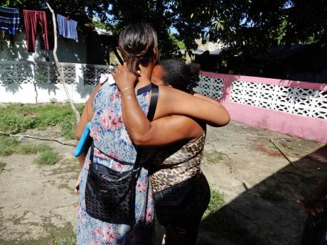 The victim’s daughter Victoria Roache consoles one of her mother’s church sisters.