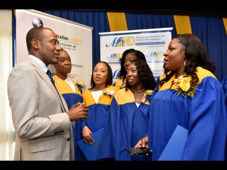 Finance and the Public Service Minister Dr Nigel Clarke interacts with some of the 23 graduates of the Tax Audit and Revenue Administration postgraduate diploma programme during a ceremony held at The Jamaica Pegasus hotel on Wednesday.