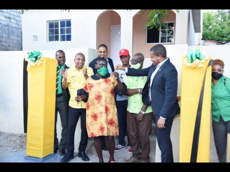 From left: Orlando Walters, who is representing Rae Town Division Councillor Rosalie Hamilton; Kingston Mayor Delroy Williams; Kingston Central Member of Parliament Donovan Williams; home recipients Juliet Cross and Lloyd Lowe; Desmond McKenzie, minister o