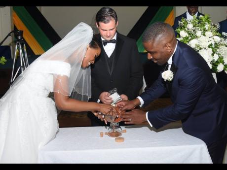 The newly-weds take part in a special spice ceremony. The bride pours jerk sauce to represent Jamaica, while the groom pours Suya pepper to represent Africa. Pastor Regan King added salt to represent God.