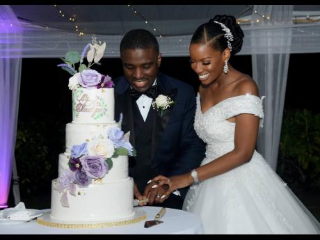 Dr Rasheed Oladipo and Dana-Marie cut their beautiful wedding cake, designed by Michelle Sohan of Treatz Bakery.