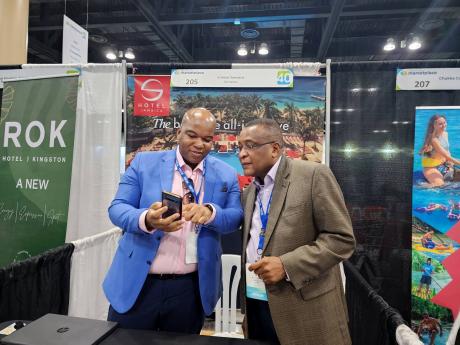 S Hotel manager Andres Cope shows former Director of Tourism Paul Pennicook news of his hotel making the top 10 list for Conde Nast Traveller Readers’ Choice Awards during Caribbean Travel Marketplace now on at the Puerto Rico Convention Center in San Ju