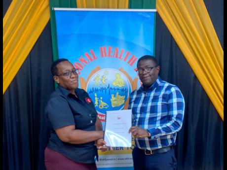 Everton Anderson, National Health Fund’s (NHF) chief executive officer and Dawn Dickenson, chief administrative officer at the HFJ shake hands to signify the latest agreement entered into to provide well-needed screening tests across the island. The cont