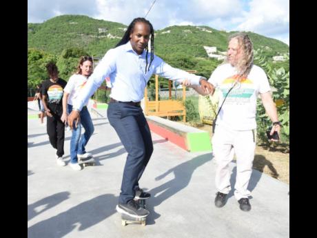 Alando Terrelonge (second right), minister of state in the Ministry of Culture, Gender, Entertainment and Sports, is assisted in maintaining his balance on a skateboard by Remy Walter (right) of Paris Skate Culture and Jamaica Skate Culture Foundation whil