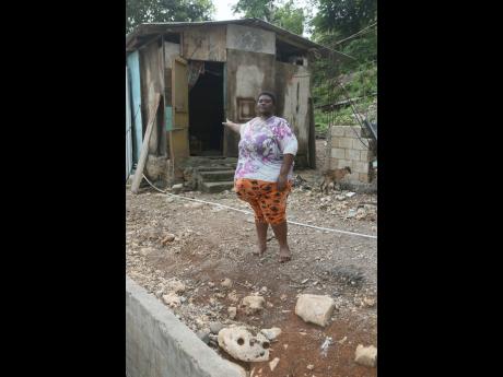 Nickiesha Bygrave, a mother of two from Bucknor in Clarendon, shows the single-room board dwelling in which she lives with her family. Bygrave is appealing for help to undergo surgery to repair a hernia, which has been causing her severe discomfort and has